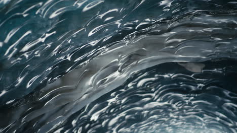 snow in cold ice cave with abstract formations and reflections tilt down