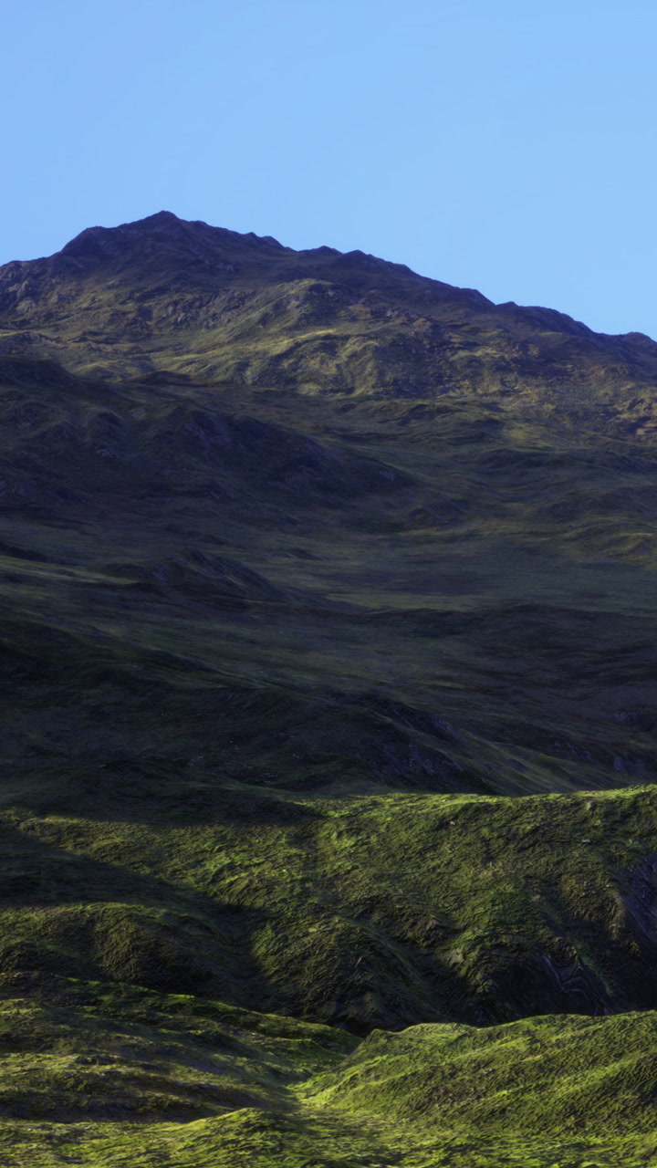 Mountain landscape with green slopes and clear blue sky in daylight