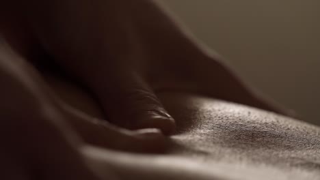 a masseuse is using her thumbs to massage a client's back alongside the spine