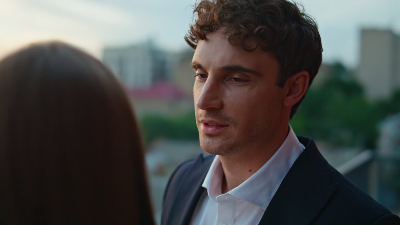 Loving husband looking wife with affection on rooftop balcony at evening closeup