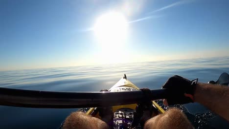 In-kayak-sportsman,-kayakers-rowing-at-mediterranean-sea-on-calm-day-with-no-waves-during-sunrise