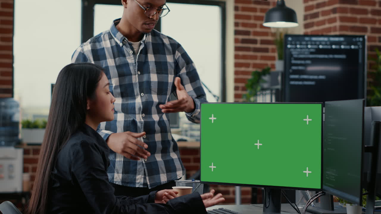 Mixed team of programmers analyzing source code looking at green screen chroma key mockup