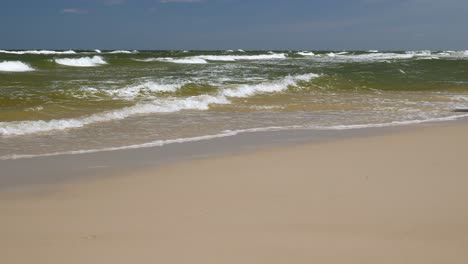 Woman-Walking-on-Beach,-Carrying-a-Baby-a-Child