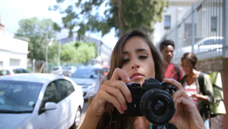 gruppo di amici che guardano la mappa mentre la donna fa clic sulla fotografia