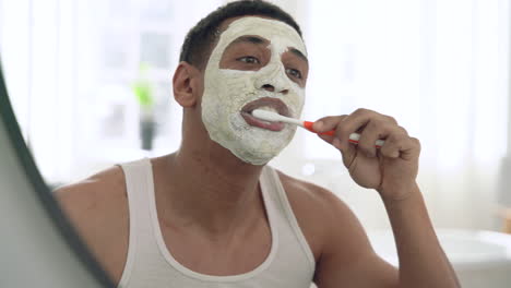 handsome black man with facial mask brushes his teeth 1