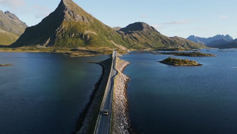 Chasing-car-over-bridge-in-northern-Europe-with-rough-landscape-towards-the-mountains