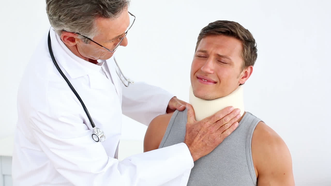 Idrottsman med nackkrage pratar med läkare.