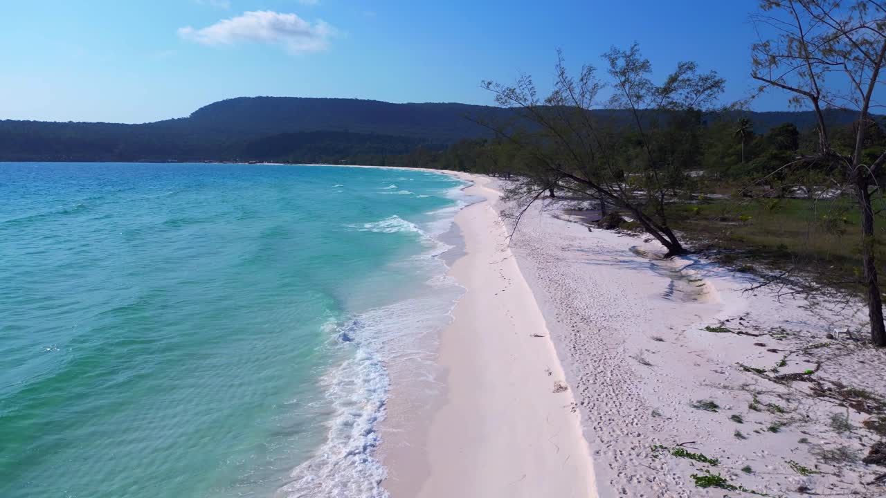 Tropical landscape showing turquoise sea washing white sand beach and green rainforest covering Koh Rong island in Cambodia. Amazing aerial view flight overflight flyover drone