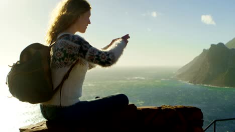 woman clicking photos with mobile phone near sea 4k