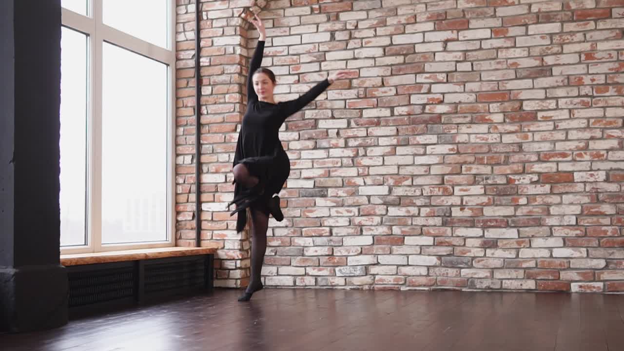 una mujer con un vestido negro realizando una danza moderna.