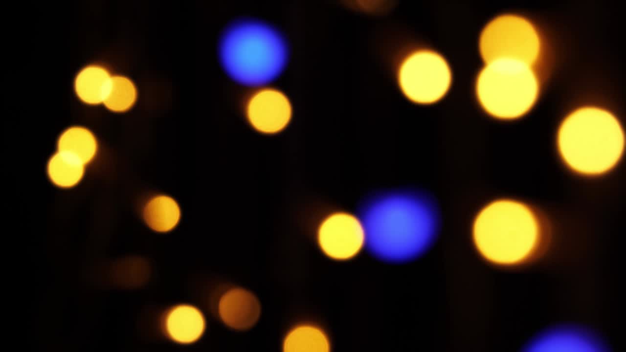 fondo bokeh abstracto en movimiento. brillantes, borrosas partículas multicolores, luces. bokeh brillante de guirnaldas en fondo oscuro. telón de fondo festivo de año nuevo o navidad