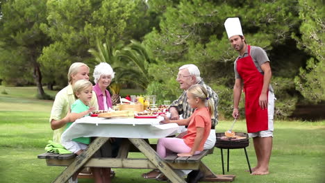 father cooking barbecue for family