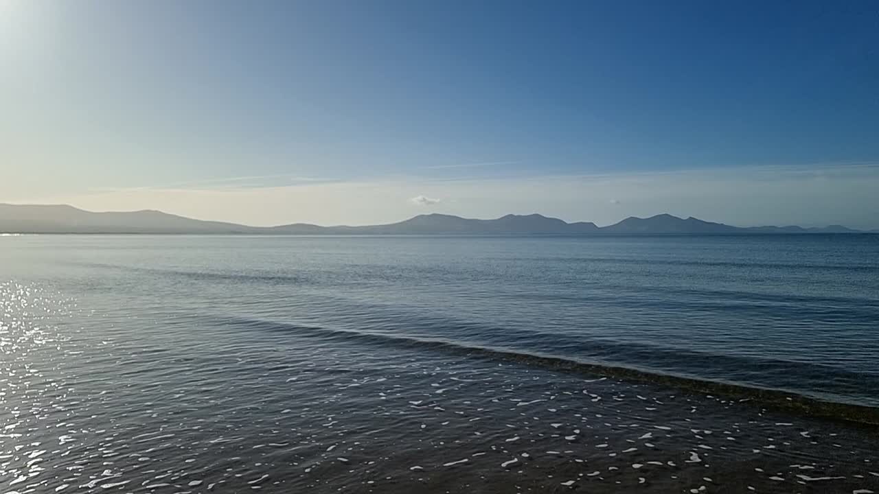 흐릿한 스노우도니아 산맥은 지평선에 반 ⁇ 이는 낙원 아일랜드 해양 풍경