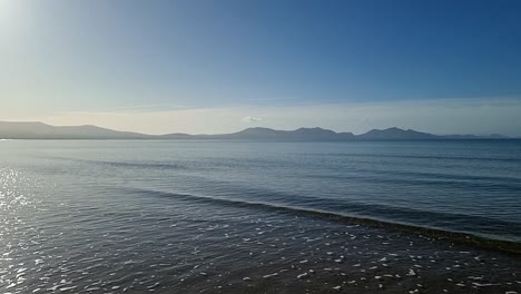 Dunstige-Snowdonia-Bergkette-Am-Horizont-Der-Schimmernden-Paradiesischen-Irischen-Meereslandschaft