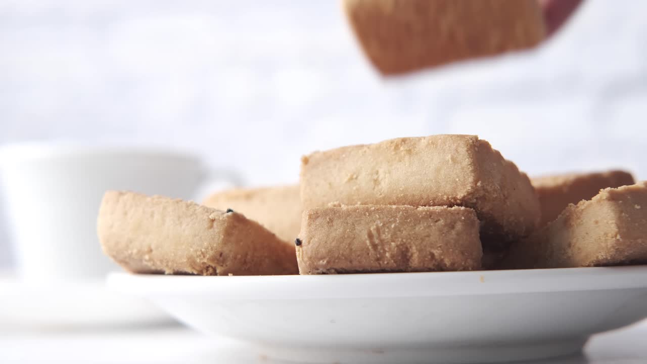 Hand Picking Biscuits from Plate