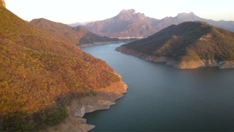 aerial view of a serene lake surrounded by mountains at sunset