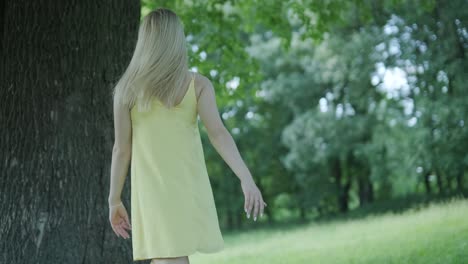 happy beautiful young girl dancing of freedom in summer park with trees in the background.