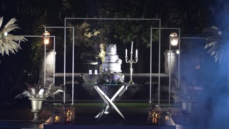 elegant outdoor wedding cake setup at night