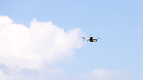 a drone hovers against a blue sky