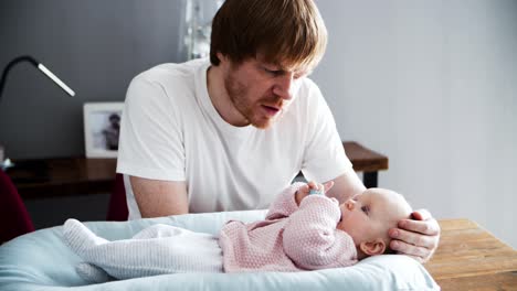 padre serio acariciando a la hija bebé en la cabeza y sonriendo