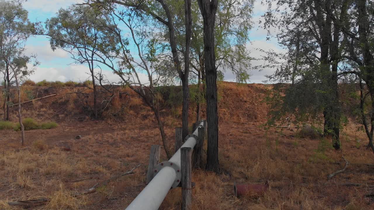 Aerial view of an outback pond with pipe and trees in Emerald, Queensland, Australia