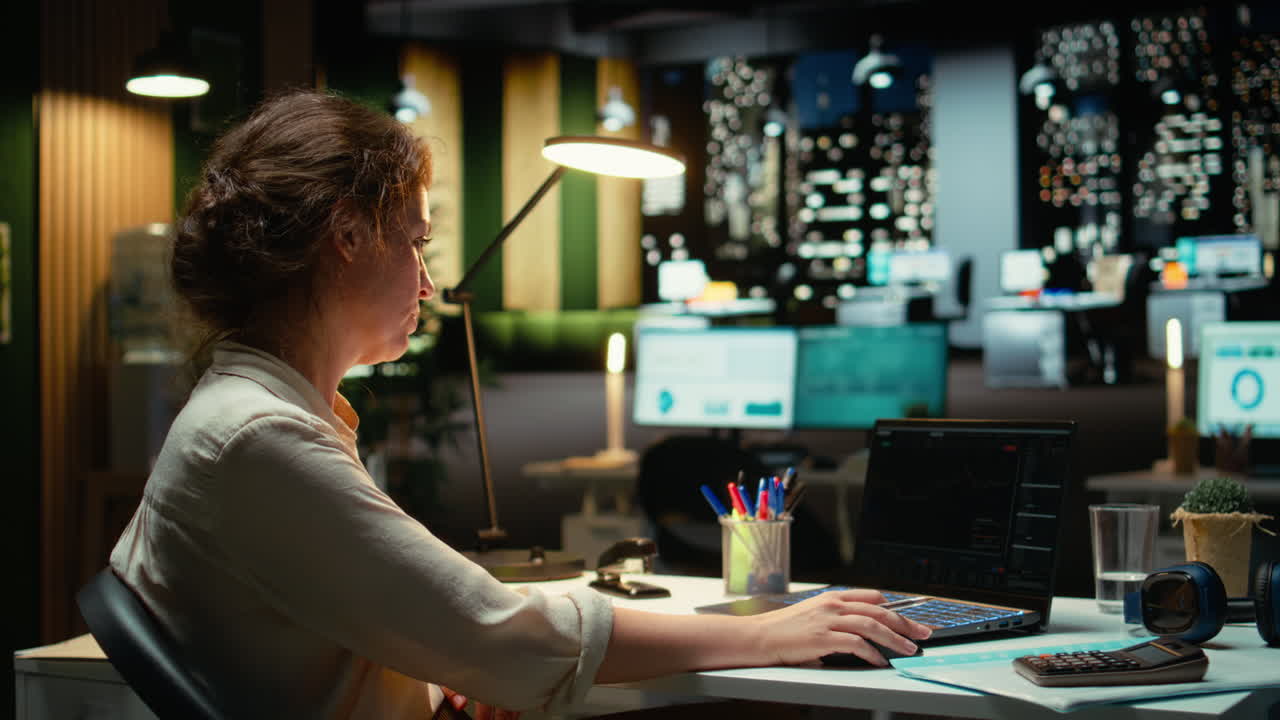 Business professional studies candlestick charts and forex data in office late