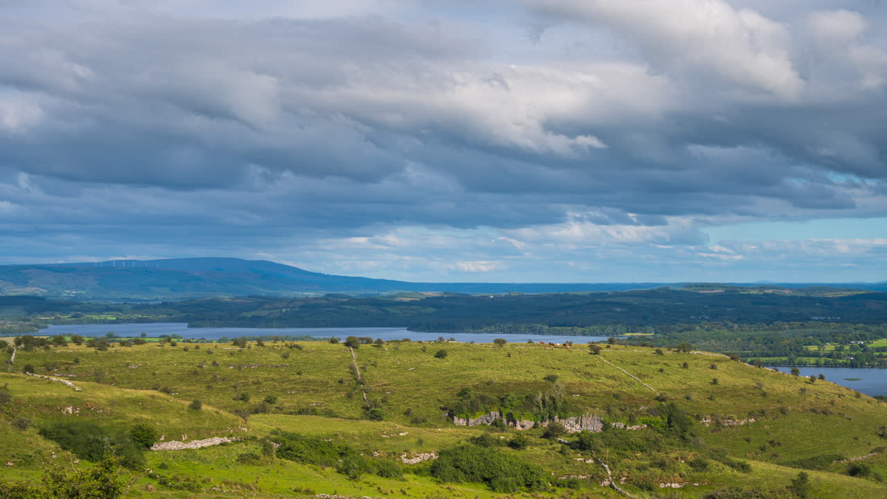 아일랜드의 슬라이고 카운티의 카로킬에서 볼 수 있는 하늘의 구름과 함께 은 날 동안 언덕의 돌벽과 호수와 함께 시골 자연 농경지의 타임 스