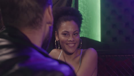 happy beautiful girl talking with man at disco