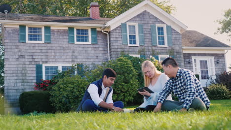 friends relaxing in yard with tablet