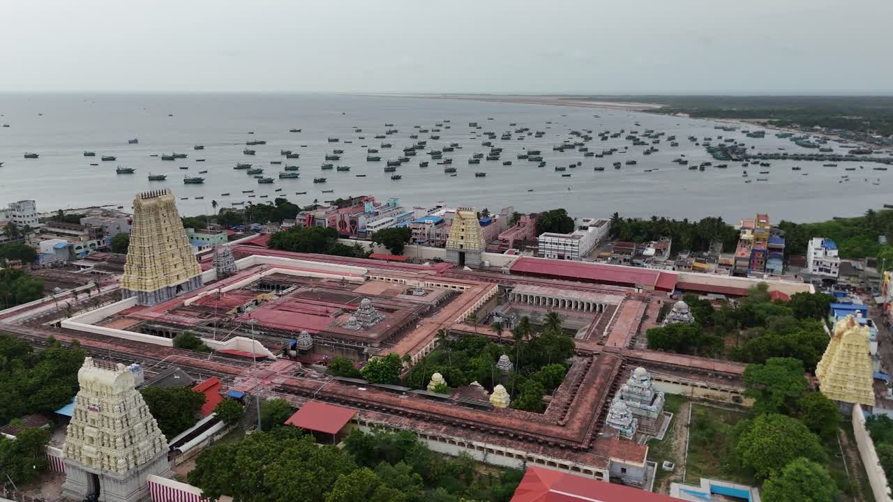An aerial video of the Ramanathaswamy Temple in Rameshwaram sacred Hindu pilgrimage site. camera would soar above the temple complex capturing the all gopurams with background of fishing boats.