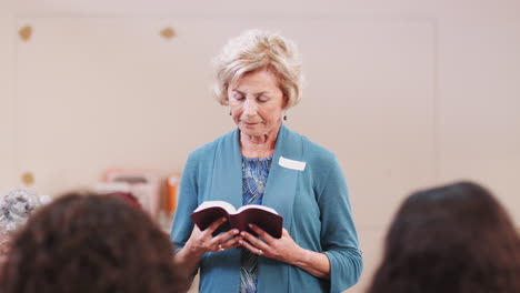 people praying at bible study meeting in community center