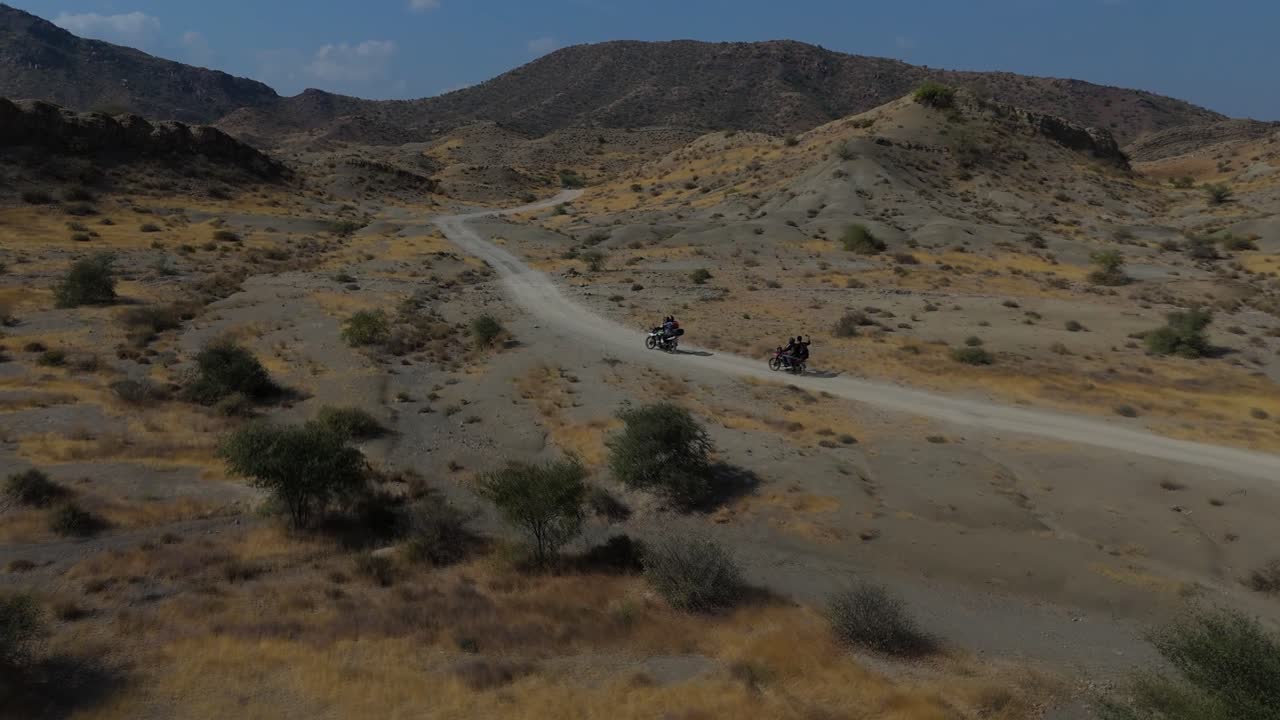 Riprese con drone di motociclisti che guidano su una pista fuoristrada nella regione arida della Valle di Kanraj.
