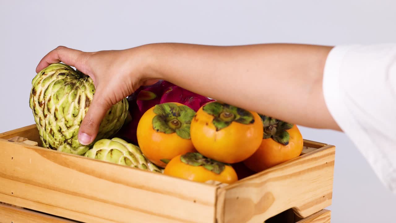recogiendo a mano la manzana de crema de frutas de la caja de frutas
