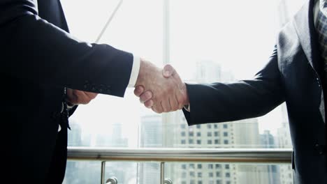 handshake between businessmen financial tower downtown city building