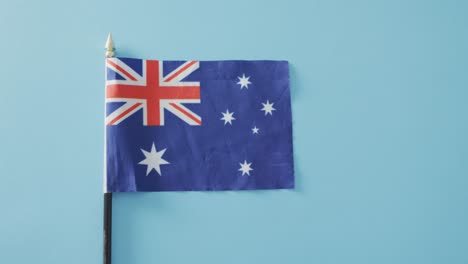 Close-up-of-australian-flag-with-stars-and-stripes-lying-on-blue-background