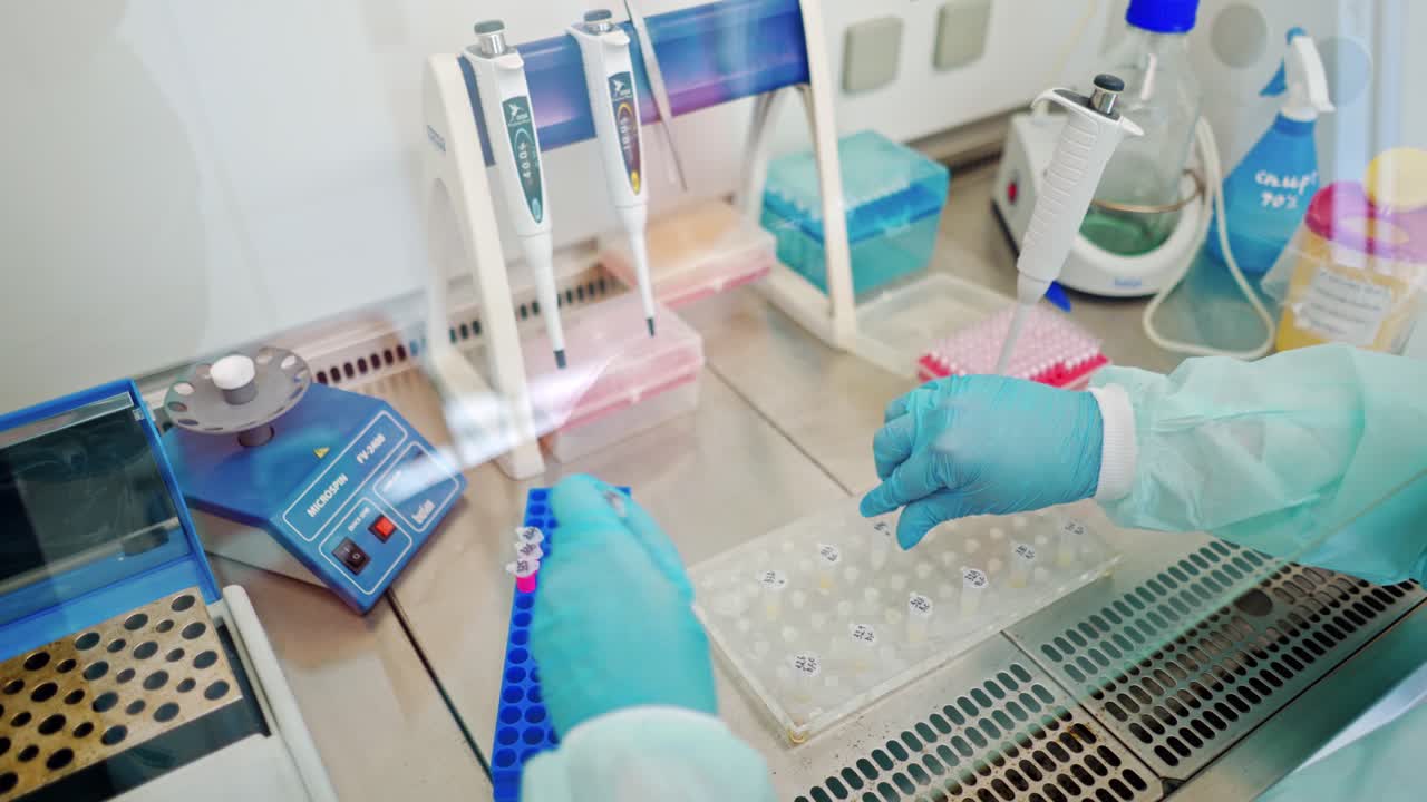Hands in sterile gloves working with test tubes. Medical worker fills vials with liquid on the table in the laboratory.