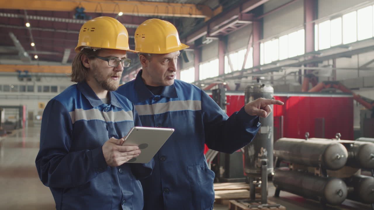 Factory Workers With Tablet Talking At Workplace