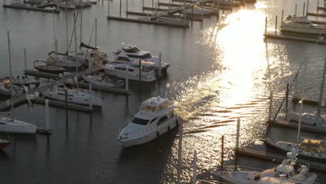 white yacht cruising through docks at the marina at sunset