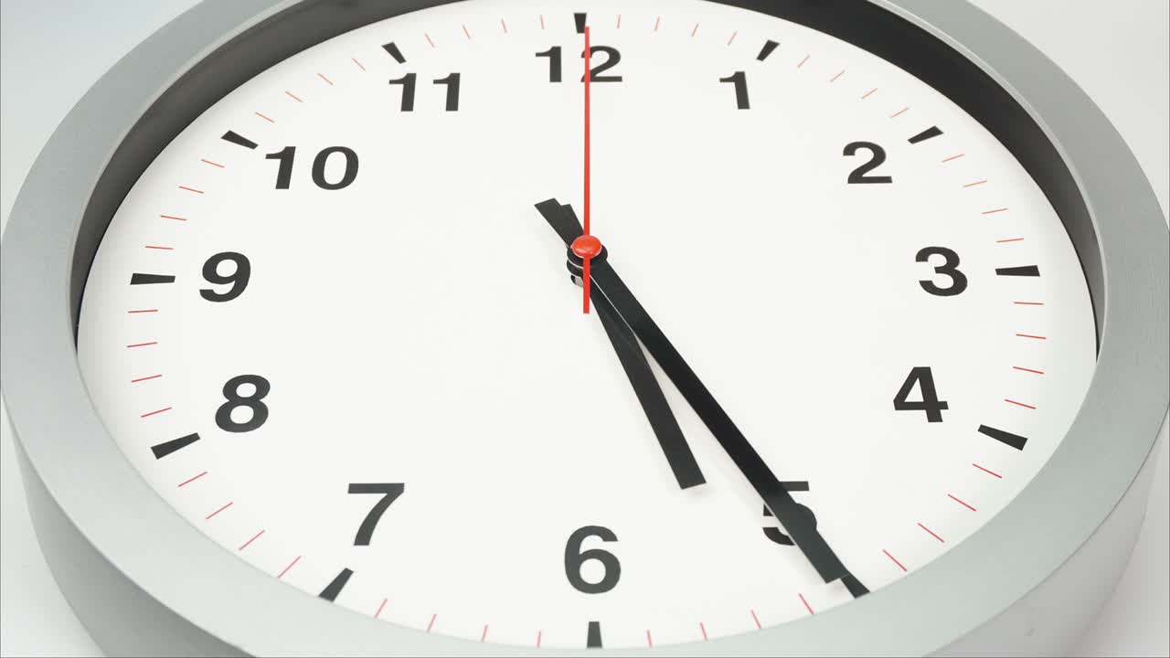 el reloj de pared gris muestra la hora a las seis.