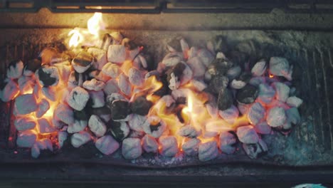 flaming charcoal in the charcoal canister of a barbecue griller in tokyo, japan - overhead slowmo shot