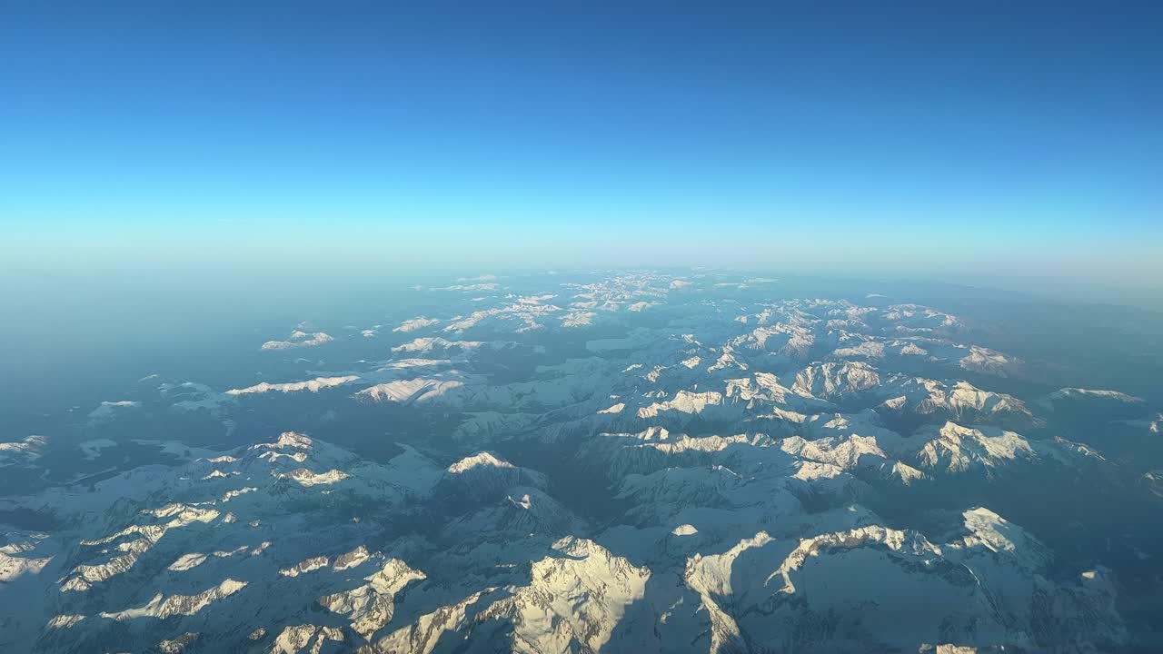 vista aérea panorámica desde la cabina de un jet de las montañas de los pirineos que vuelan hacia el norte justo antes del atardecer