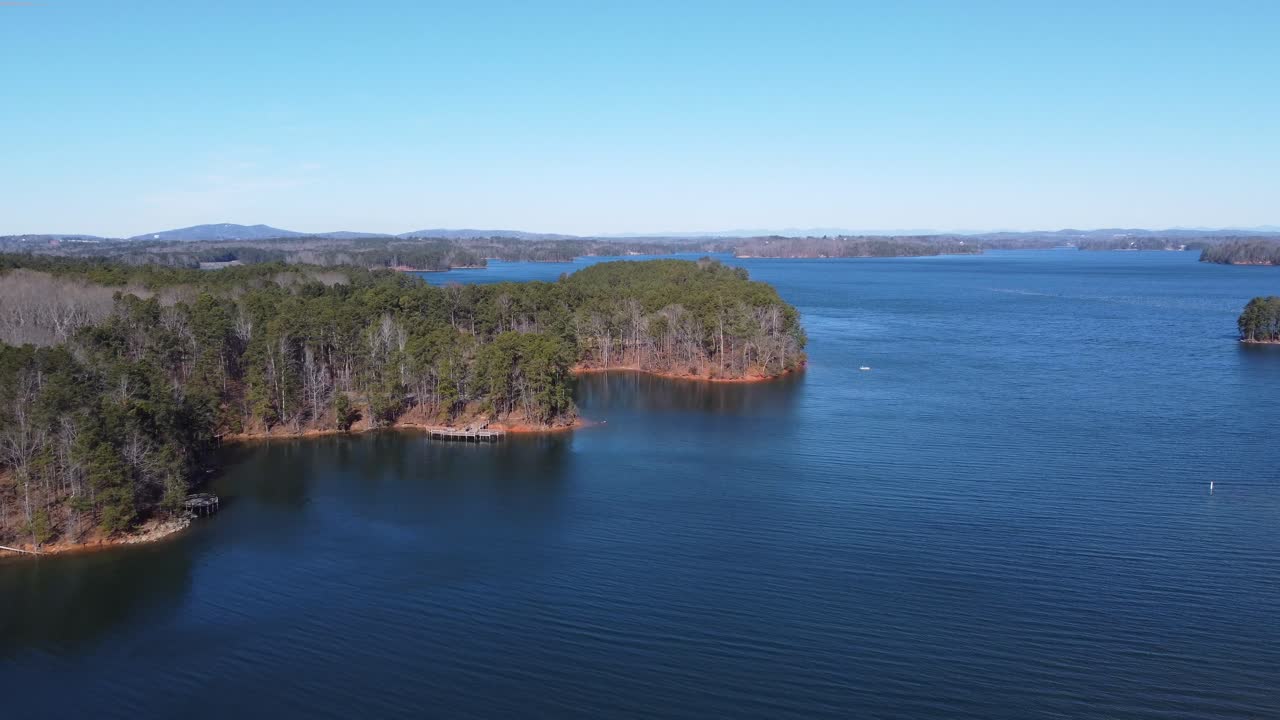 Maisemajärvimaisema, jossa puita ja laituri