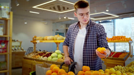 hombre comprando naranjas en una tienda de comestibles