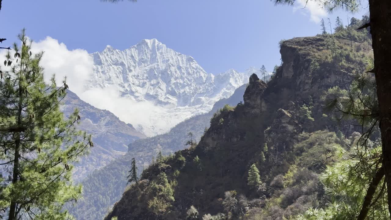 Experience the beauty of nature with blue skies, snow-covered peaks, and vibrant green forests in perfect harmony.