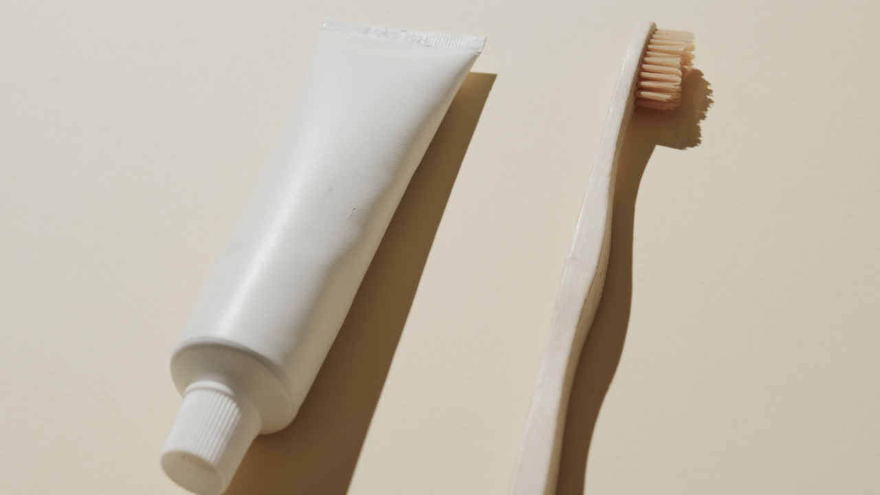 Close up of toothbrush and toothpaste on beige background