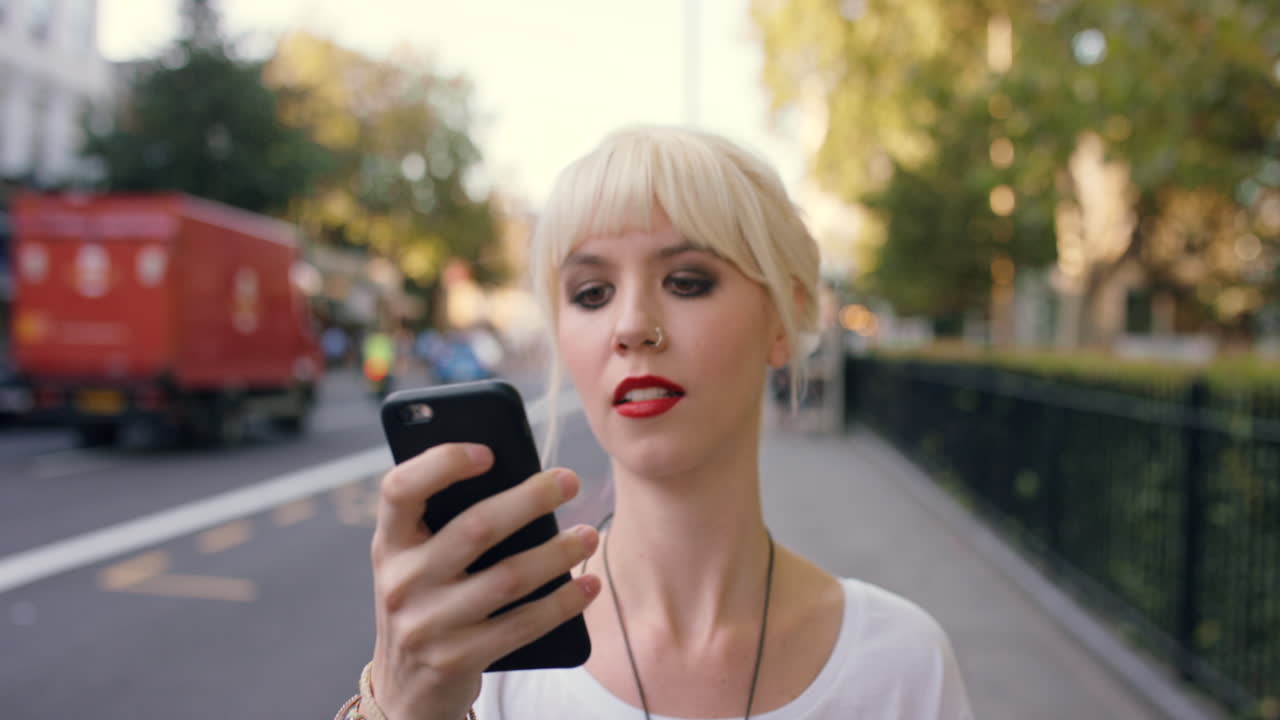 mujer mirando su teléfono en la calle