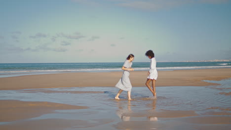 Novias-Felices-Abrazan-La-Playa-Bajo-La-Luz-Del-Sol.-Pareja-De-Lesbianas-Verticales-Riendo-Océano