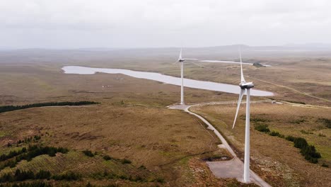 Toma-Aérea-De-Turbinas-Eólicas-Cerca-De-Un-Lago-Escocés-En-La-Isla-De-Lewis.