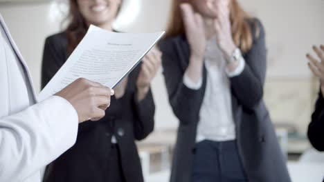 boss holding papers and colleagues applauding