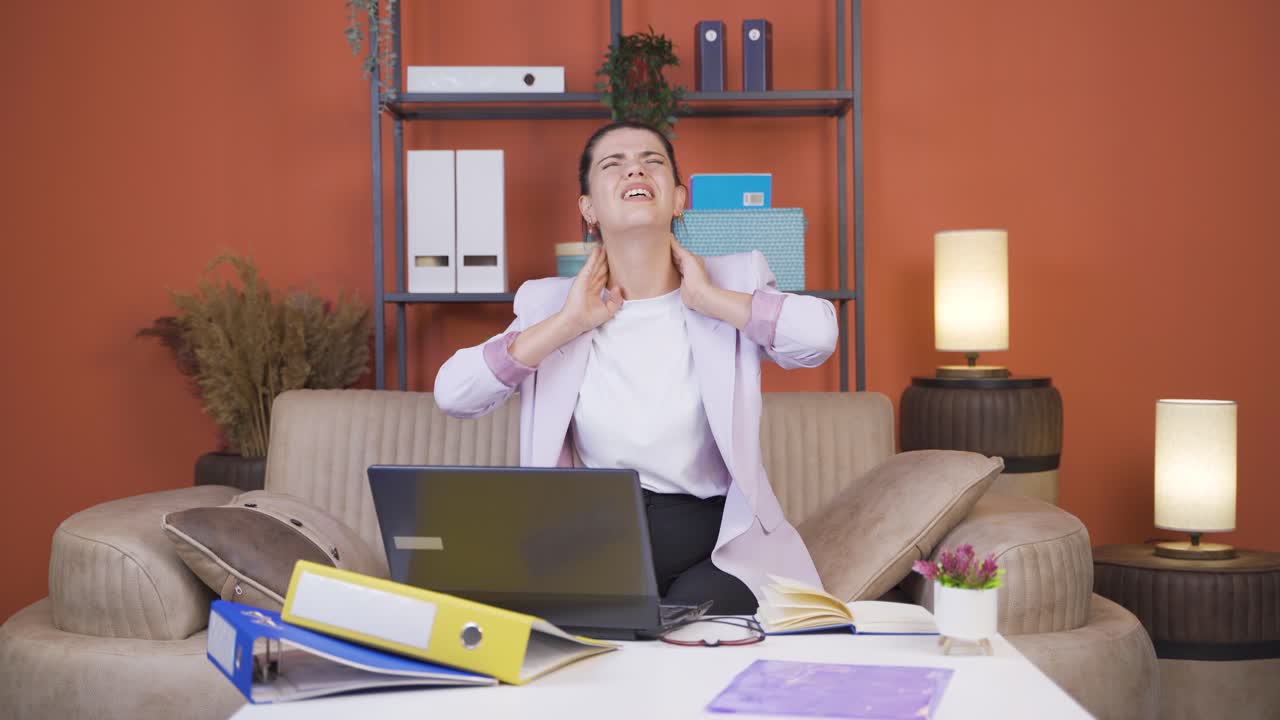 una joven trabajadora de oficina en casa tiene dolor de cuello.